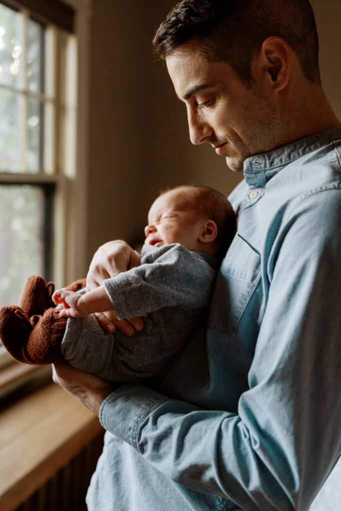 father gazes down at infant son