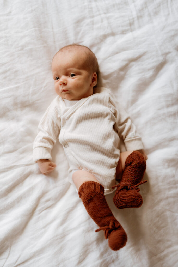 infant boy dressed in long sleeve onesie and thigh high socks