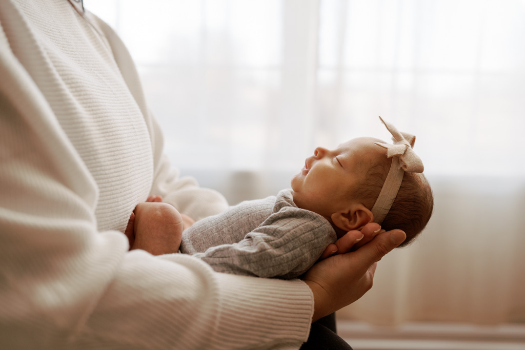 infant baby sleeps comfortably in her mothers hands.
