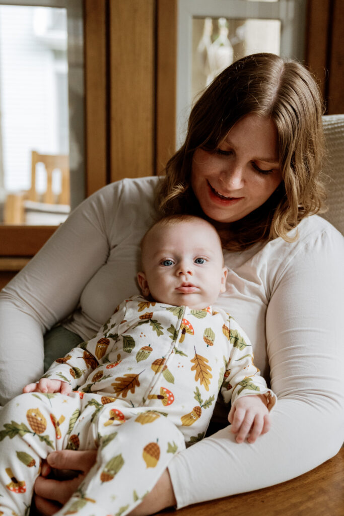 mother gazing lovingly at baby while baby looks on
