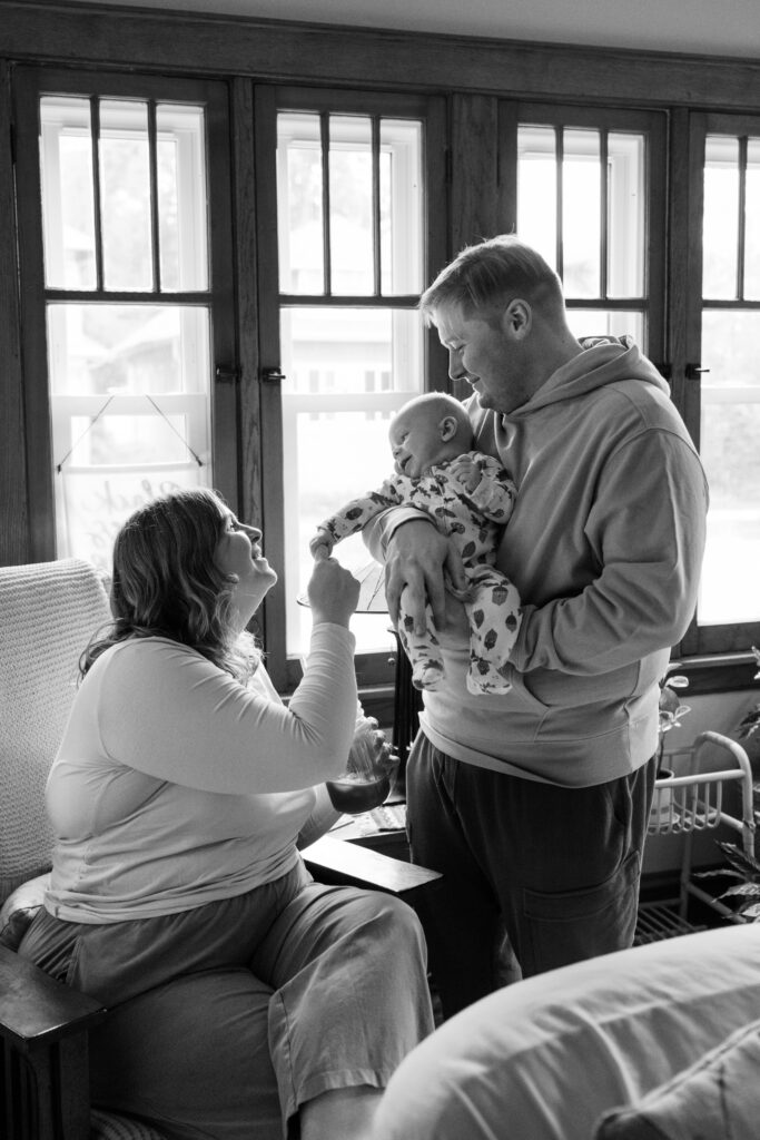 Father holding baby looking at mom