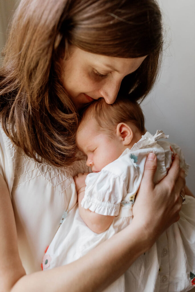 mother lovingly sniffs her baby's head